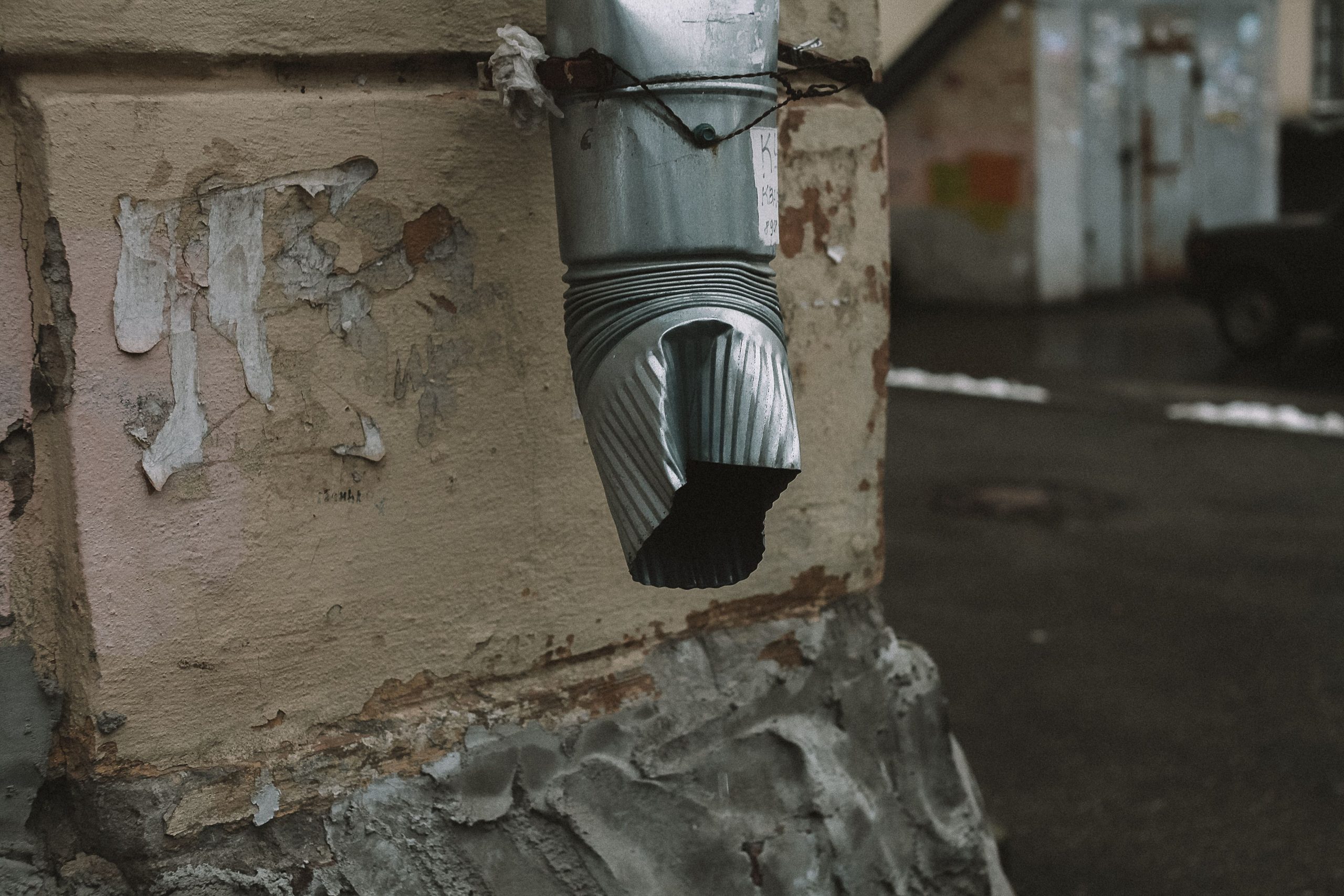 Conduite métallique usée sur mur délabré
