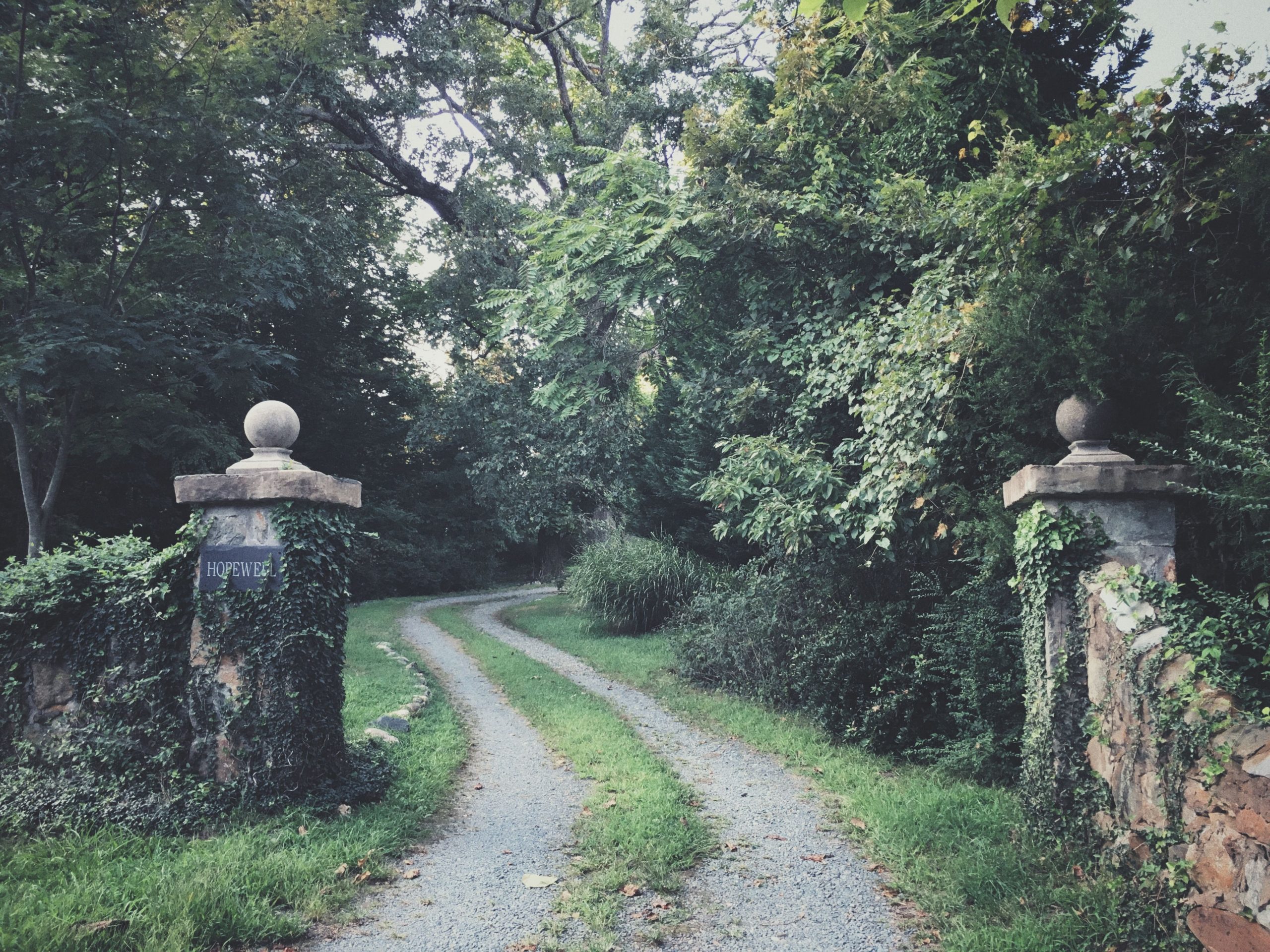 Chemin rural avec anciens piliers de portail battant