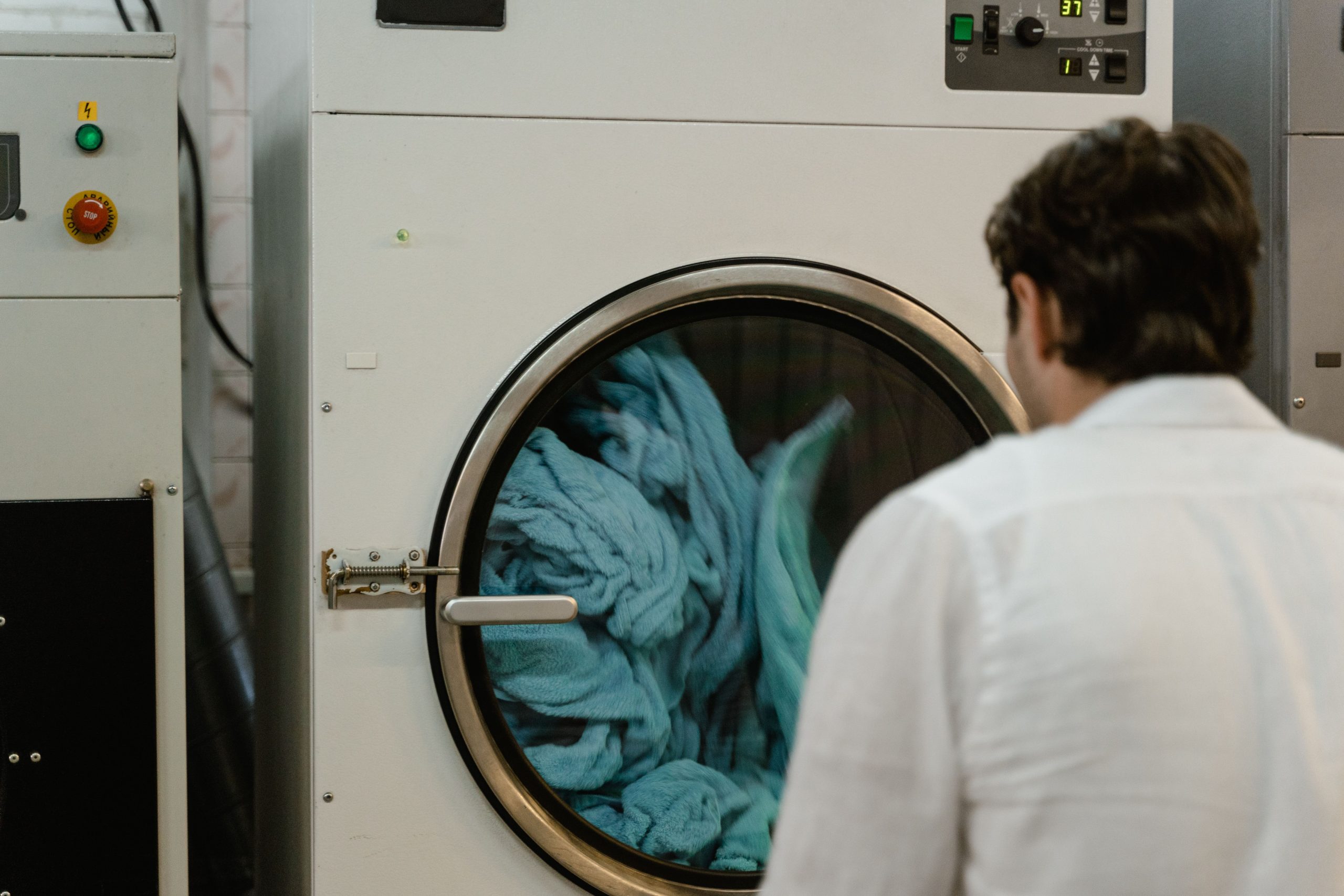 Homme observant cycle de lavage en laverie