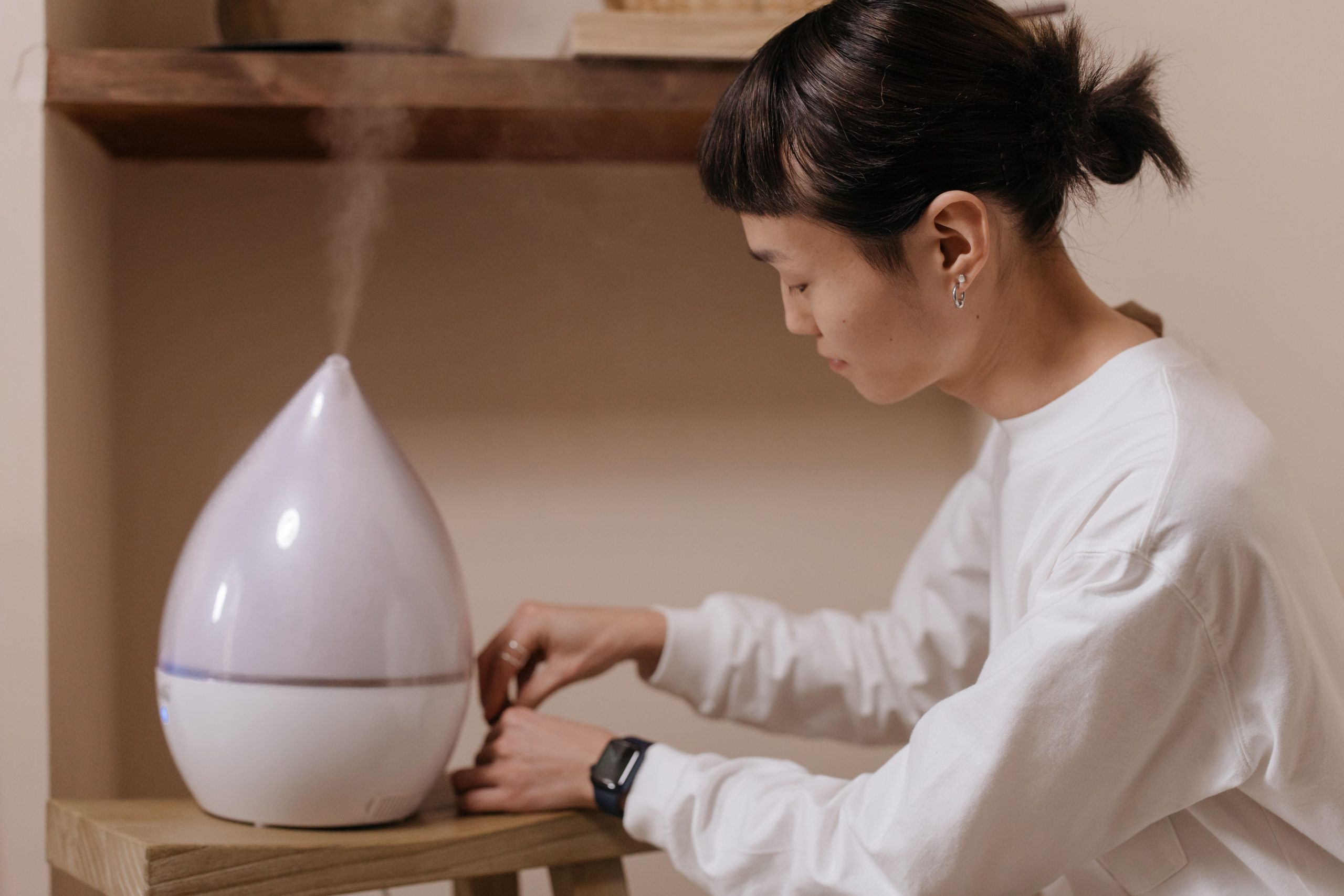 Femme réglant un humidificateur d'air intérieur