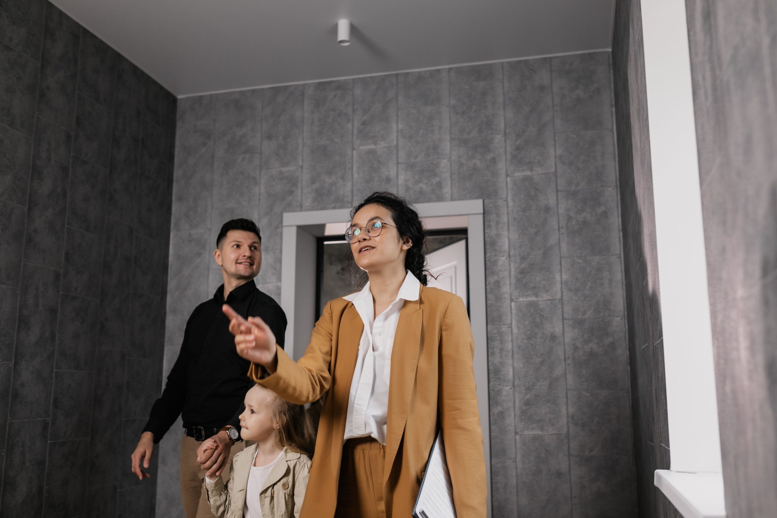 Famille visitant un logement moderne avec un agent professionnel
