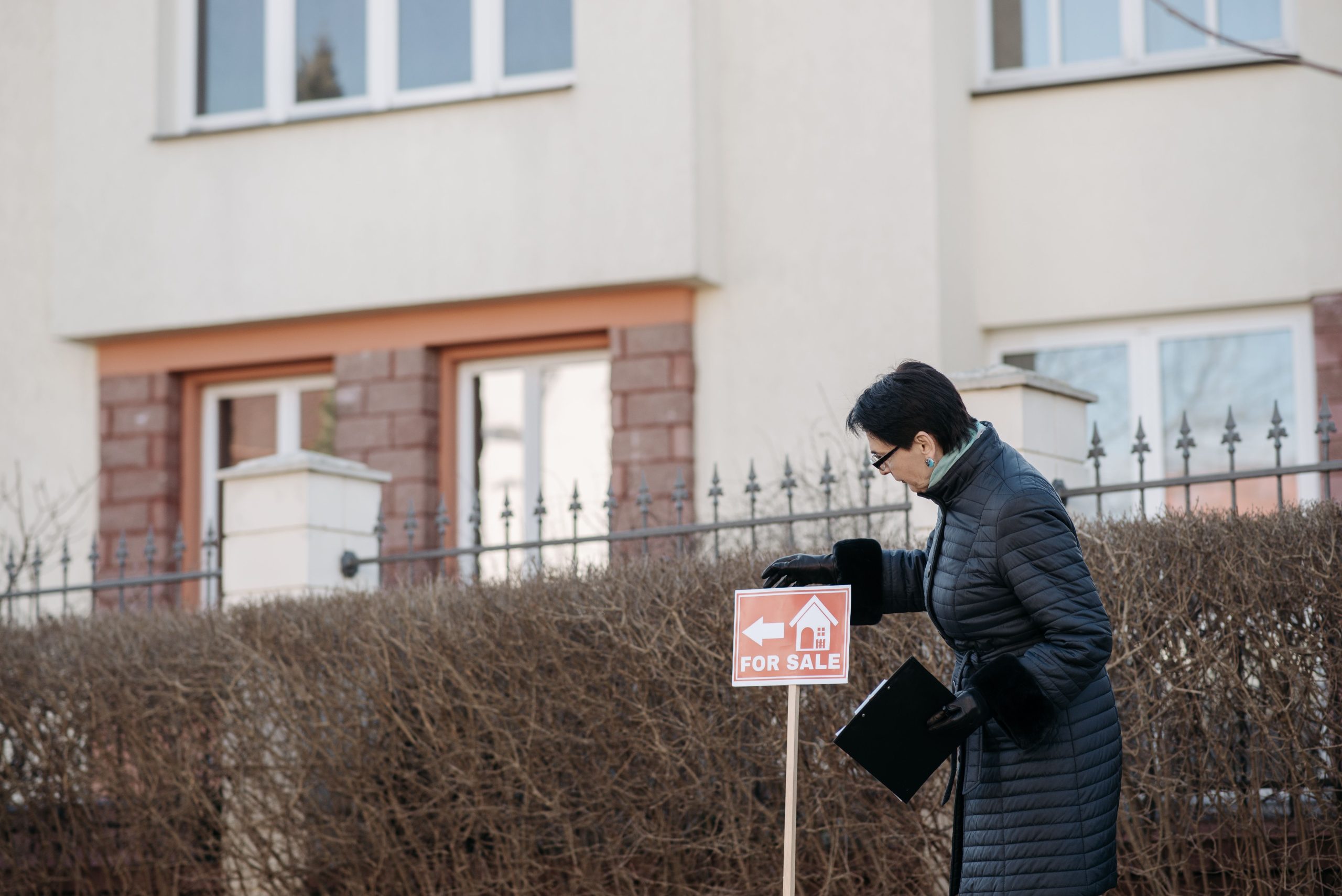 Agent immobilier pose panneau vente